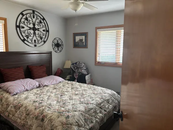 a bedroom with a bed and painting on the wall
