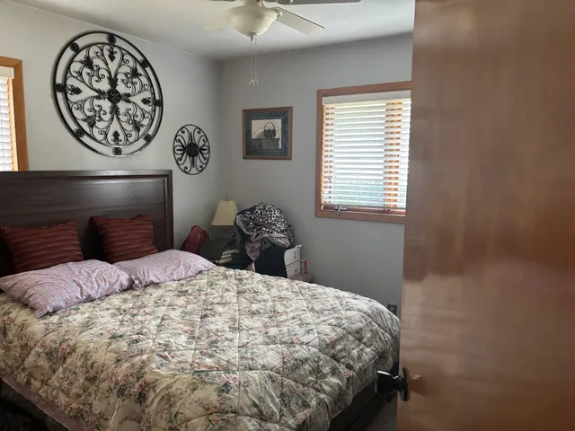 a bedroom with a bed and painting on the wall