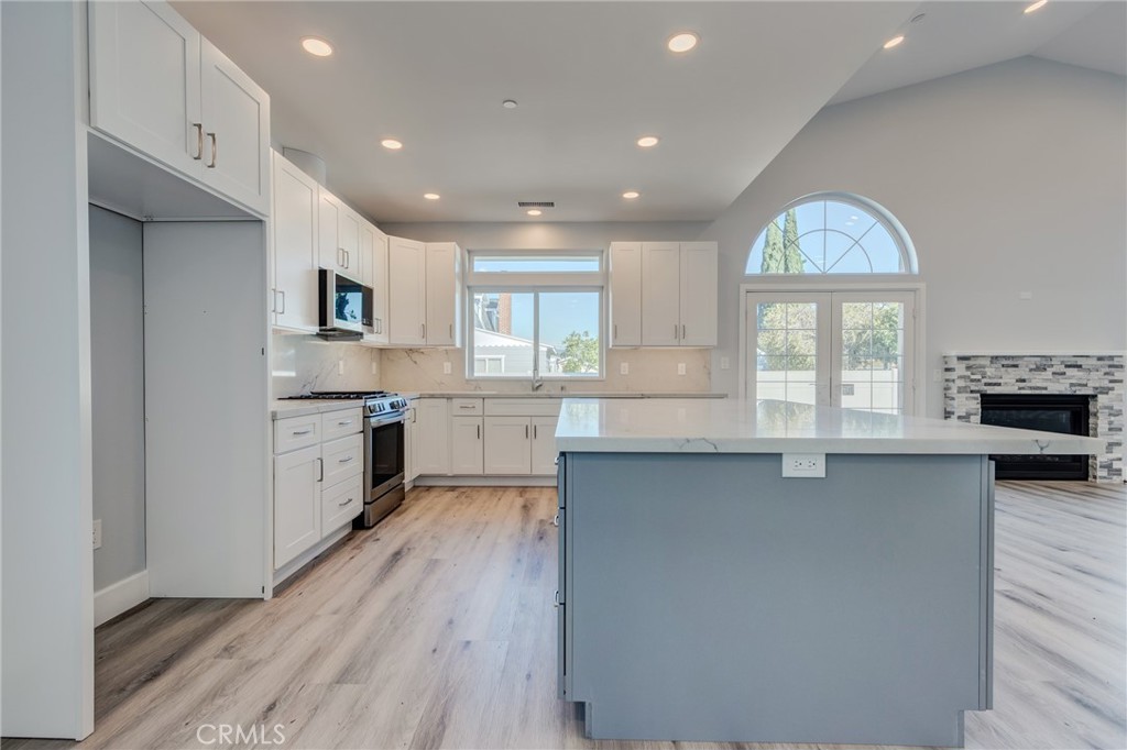 11128 Stamy Road Whittier, CA 90604 - Photo 13 of 40 a kitchen with kitchen island granite countertop a stove a sink a refrigerator and a cabinets