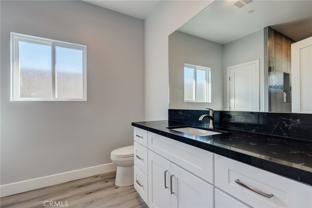 11128 Stamy Road Whittier, CA 90604 - Photo 28 of 40 a bathroom with a granite countertop sink a toilet and a mirror