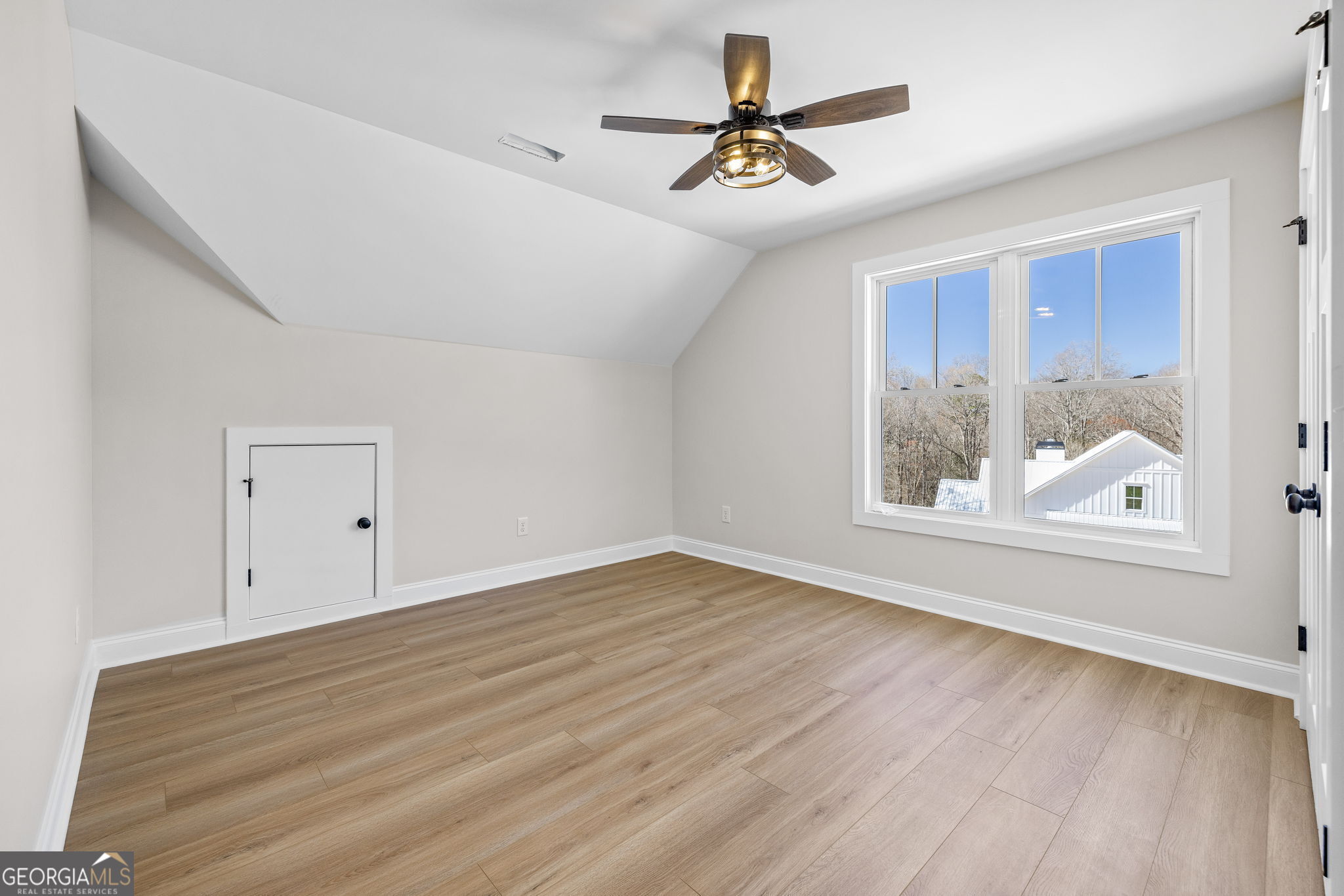 409 Roper Drive Clarkesville, GA 30523 - Photo 19 of 32 a view of an empty room with a window and wooden floor