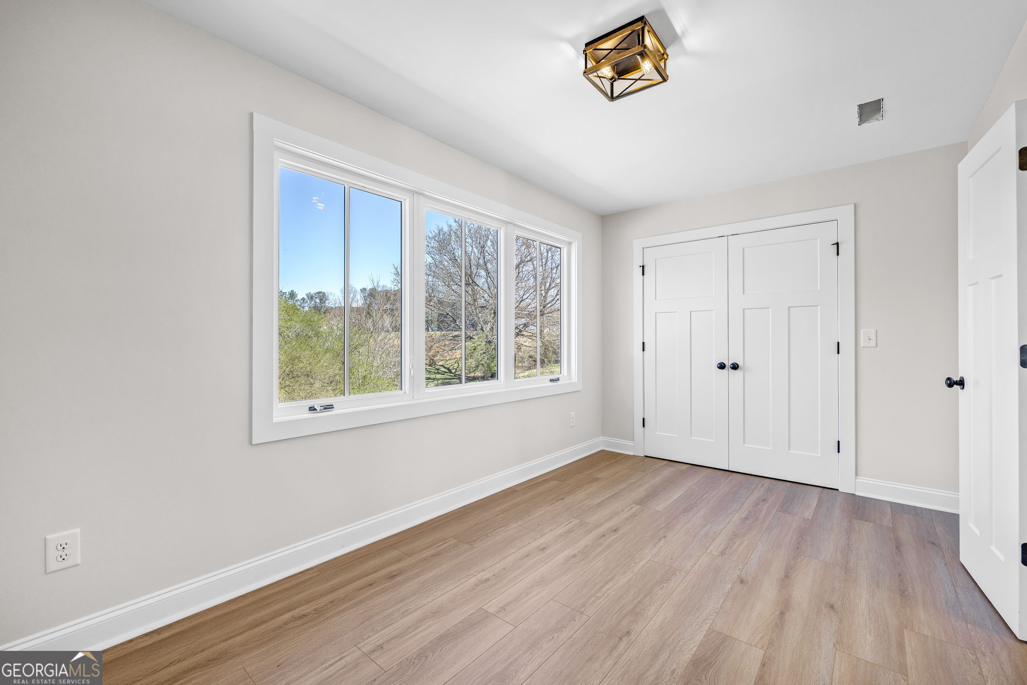 409 Roper Drive Clarkesville, GA 30523 - Photo 21 of 32 a view of an empty room with a window and wooden floor