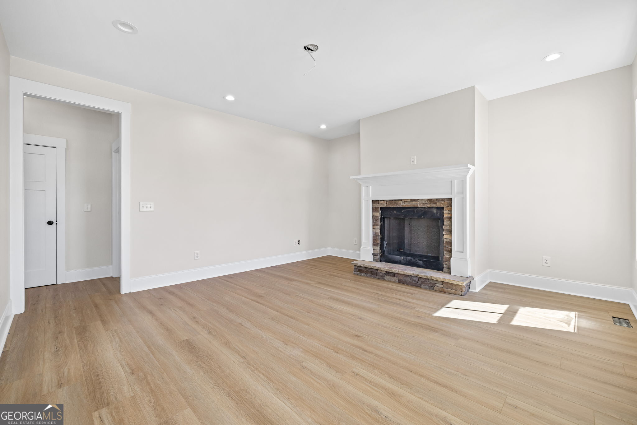 409 Roper Drive Clarkesville, GA 30523 - Photo 5 of 32 an empty room with wooden floor fireplace and window