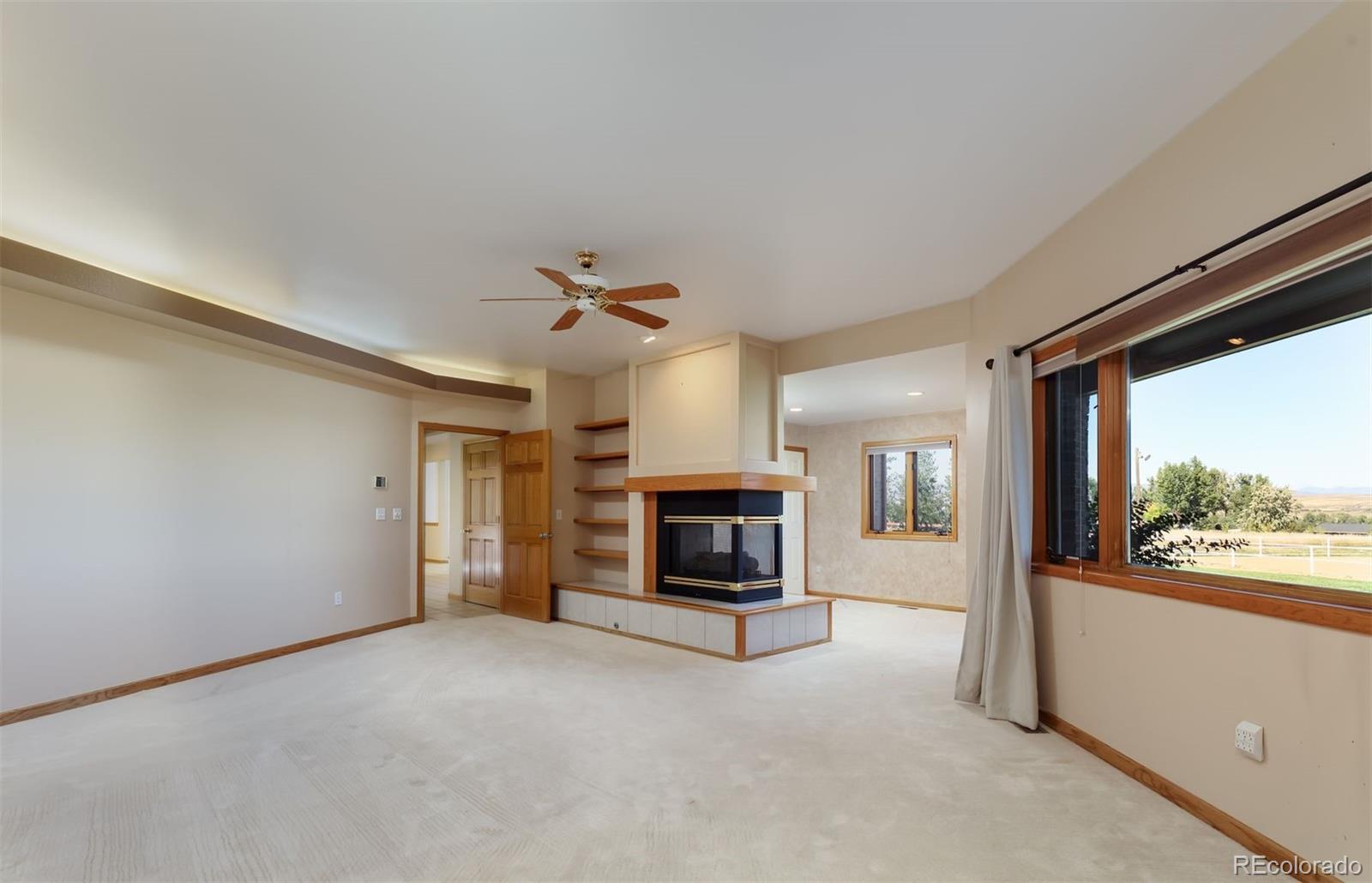 9741 Isabelle Road Lafayette, CO 80026 - Photo 22 of 39 a view of a livingroom with an empty space and a fireplace