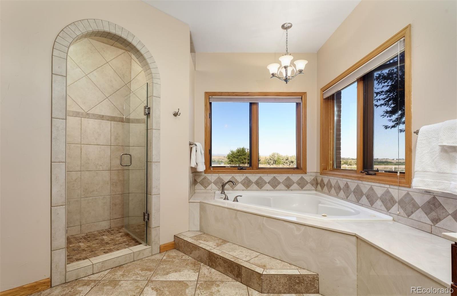 9741 Isabelle Road Lafayette, CO 80026 - Photo 25 of 39 a spacious bathroom with a granite countertop sink a large mirror and a shower