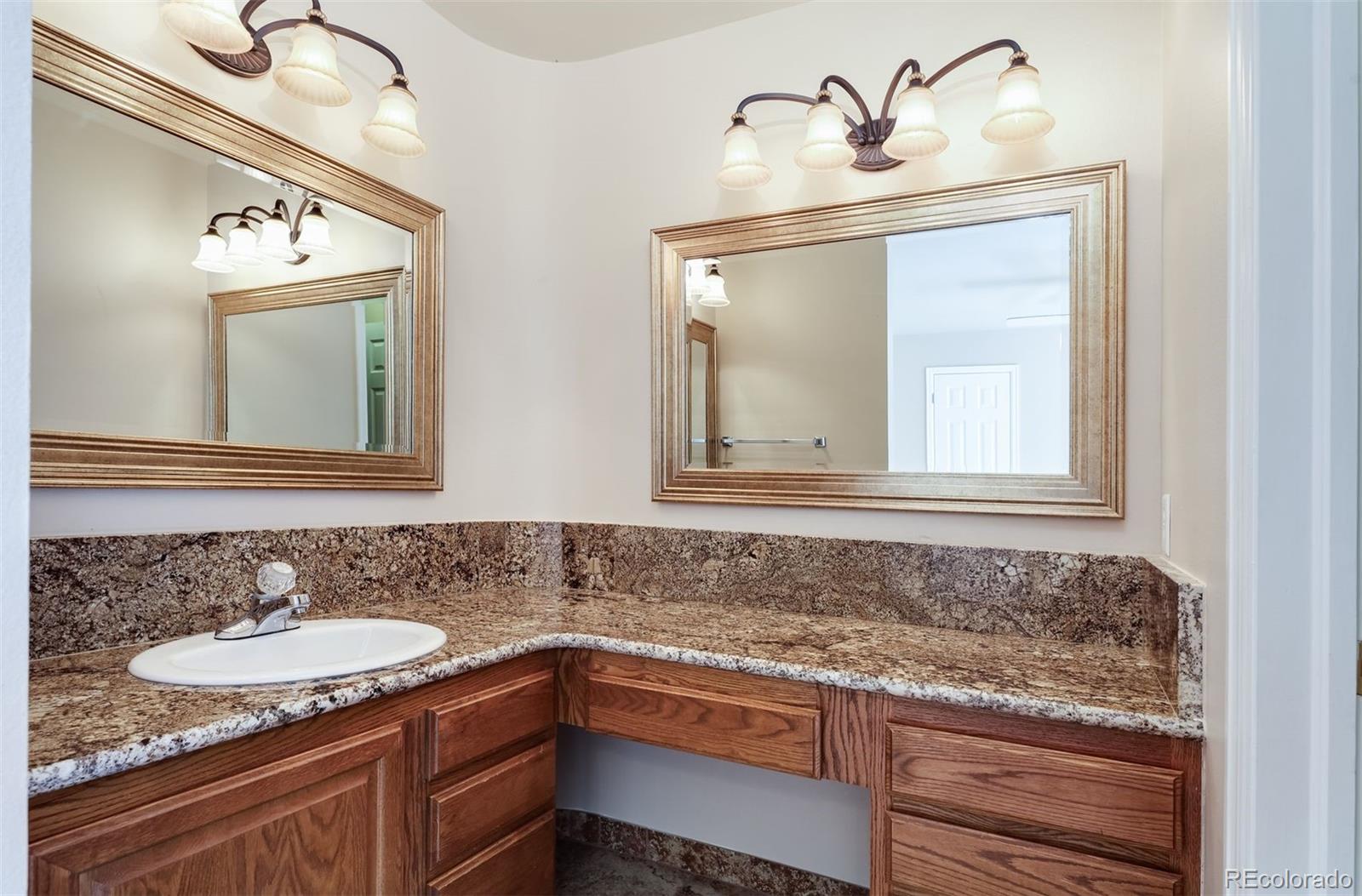9741 Isabelle Road Lafayette, CO 80026 - Photo 28 of 39 a bathroom with a granite countertop sink and a mirror