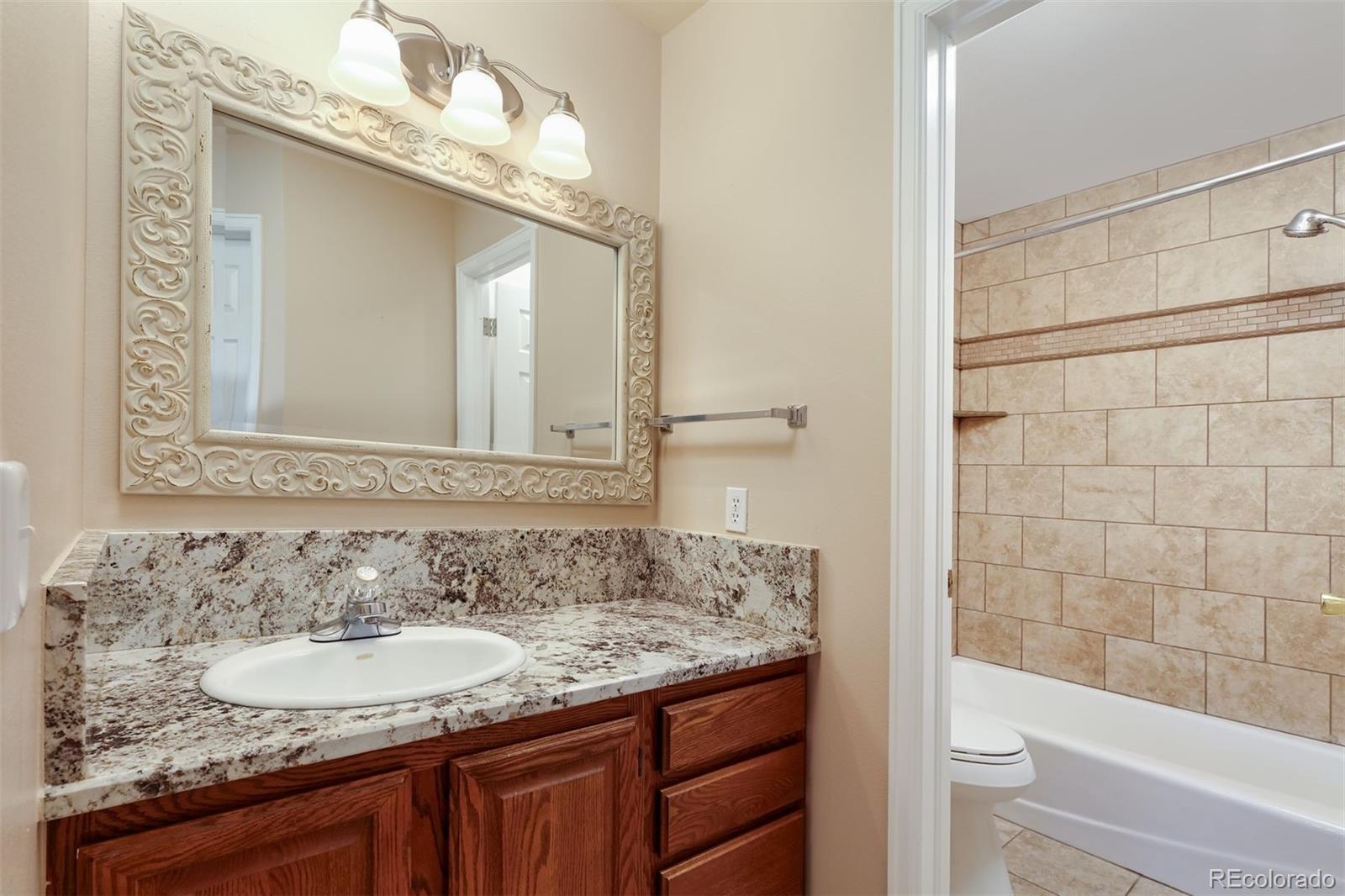 9741 Isabelle Road Lafayette, CO 80026 - Photo 33 of 39 a bathroom with a granite countertop sink and a mirror