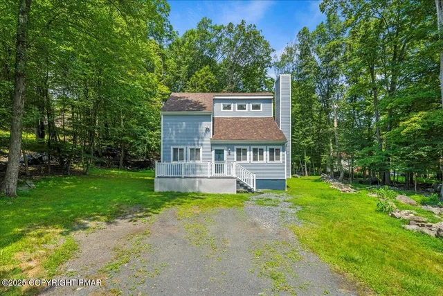 an aerial view of a house with swimming pool a yard and a outdoor seating