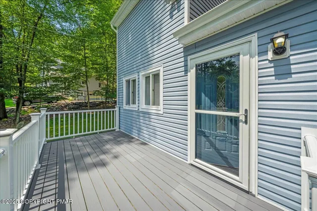 a view of an empty room with chandelier fan and fire place