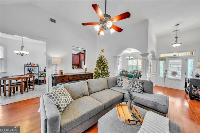 a living room with furniture a chandelier and a dining table