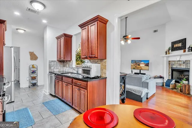 a kitchen with stainless steel appliances granite countertop a sink cabinets and a window