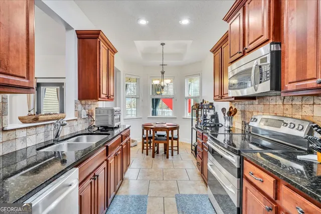 a kitchen with stainless steel appliances granite countertop a sink stove and cabinets