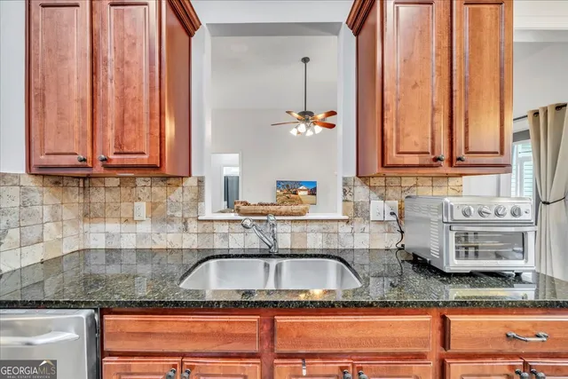 a kitchen with granite countertop a sink a stove and cabinets