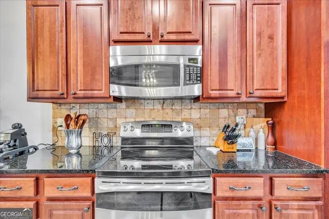 a kitchen with granite countertop wood cabinets and stainless steel appliances
