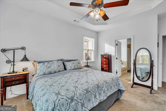 a bedroom with a large bed and a chandelier