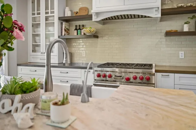 a kitchen with a stove and a white wooden cabinets