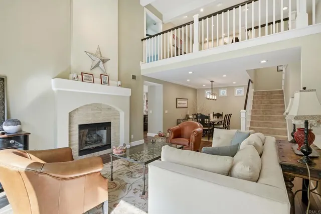 a living room with furniture a fireplace and a large mirror