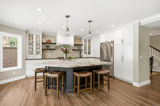 a kitchen with stainless steel appliances granite countertop a kitchen island hardwood floor and a sink