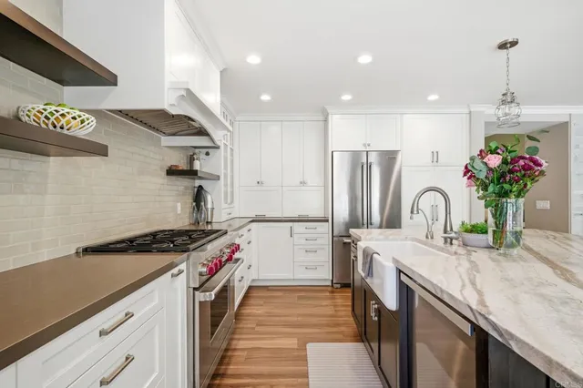 a kitchen with stainless steel appliances granite countertop a sink stove and refrigerator