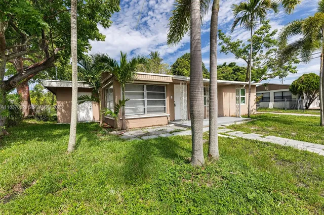a view of a house with backyard and a tree