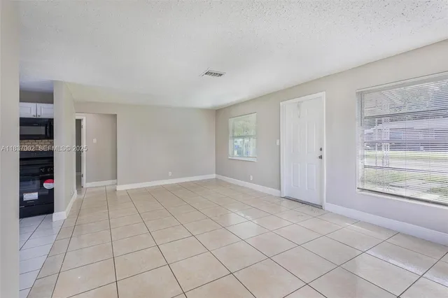 a view of an empty room with window and cabinet