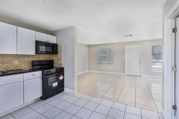 a kitchen with granite countertop a sink and a stove top oven