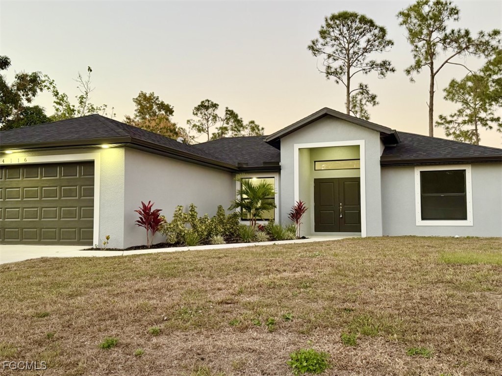 4116 2nd Street Southwest Lehigh Acres, FL 33976 - Photo 1 of 5 a front view of a house with a yard and garage