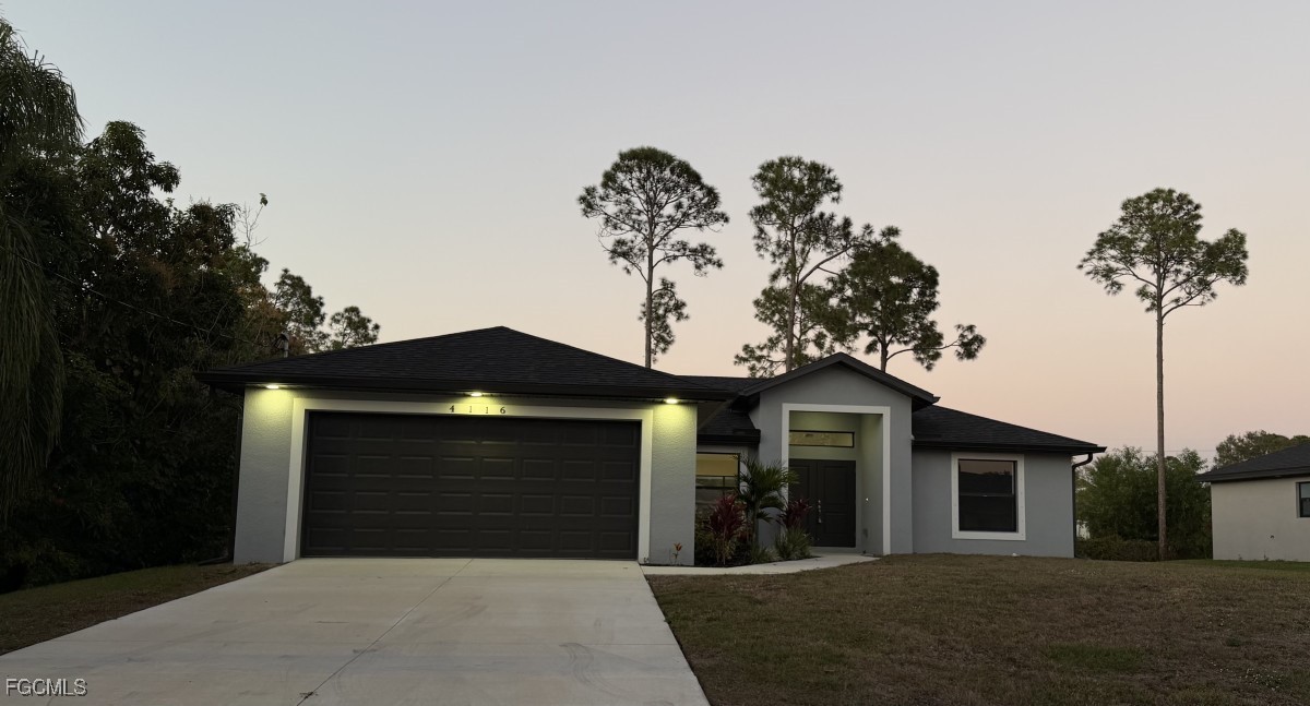 4116 2nd Street Southwest Lehigh Acres, FL 33976 - Photo 2 of 5 a front view of a house with a yard and garage