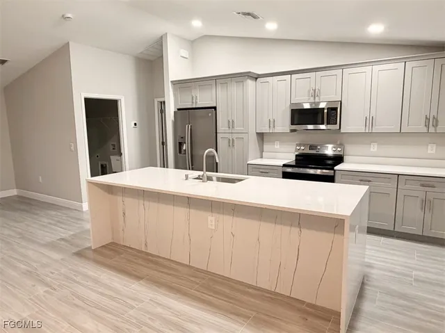 a kitchen with stainless steel appliances a sink a stove a microwave and cabinets