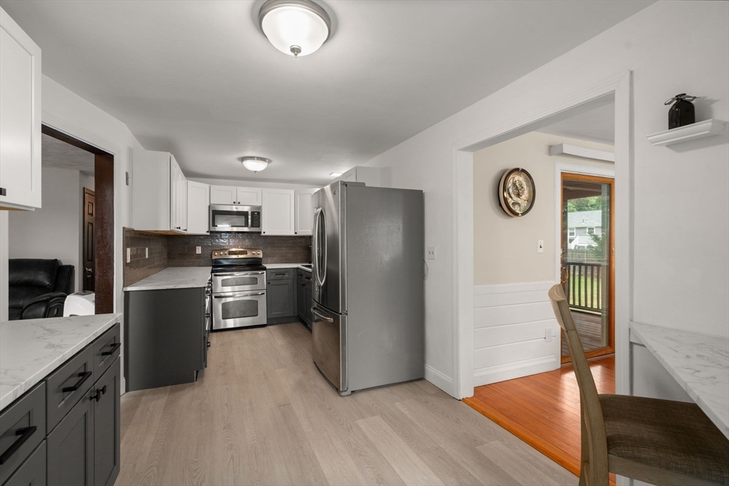 9 Laurel Lane Bellingham, MA 02019 - Photo 11 of 30 a kitchen with a refrigerator a stove top oven and kitchen island