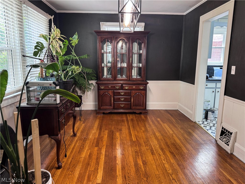 7121 North Lima Road Youngstown, OH 44514 - Photo 14 of 37 Dining area featuring a wood-finish floor, chair rail molding, and a visible doorway leading to a kitchen with patterned floor tiles