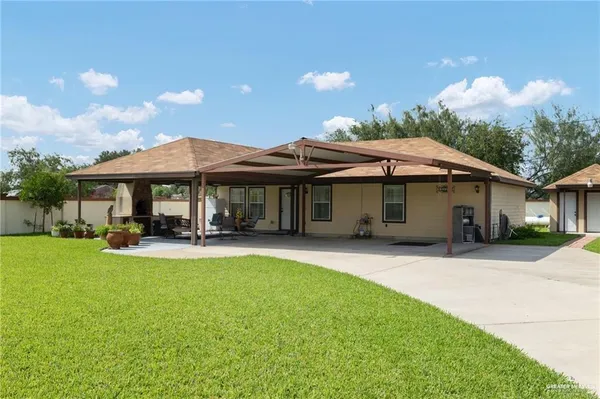 a front view of a house with patio and garden