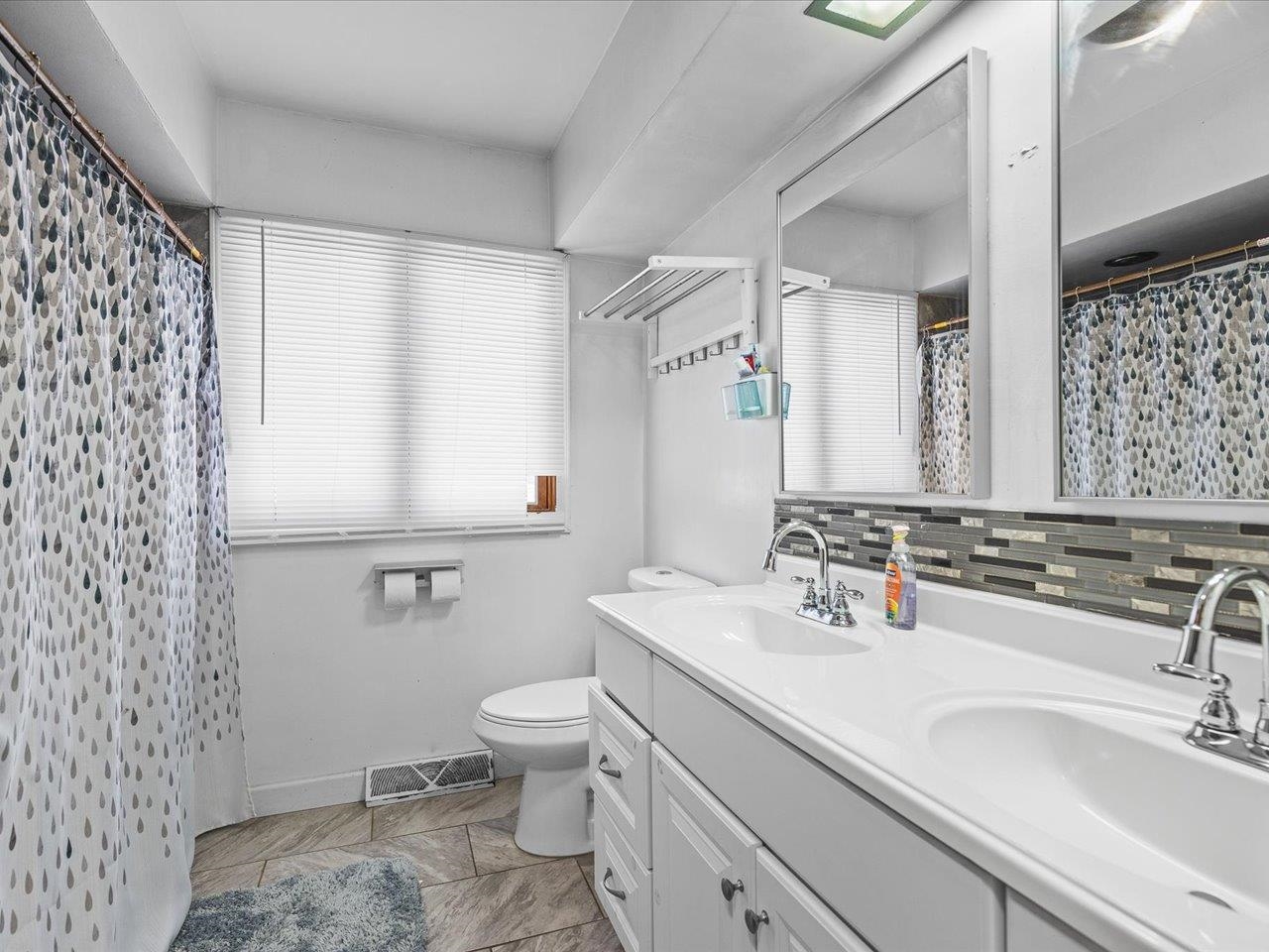 3215 Rural Street Rockford, IL 61107 - Photo 15 of 25 a bathroom with a granite countertop sink a toilet and a mirror