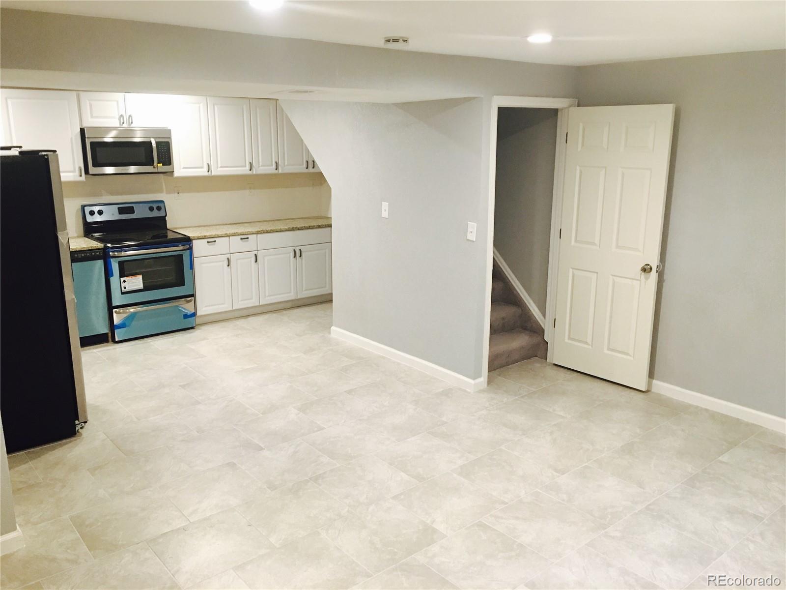 5542 Scranton Street Denver, CO 80239 - Photo 12 of 16 a view of kitchen with kitchen island a sink stainless steel appliances and cabinets