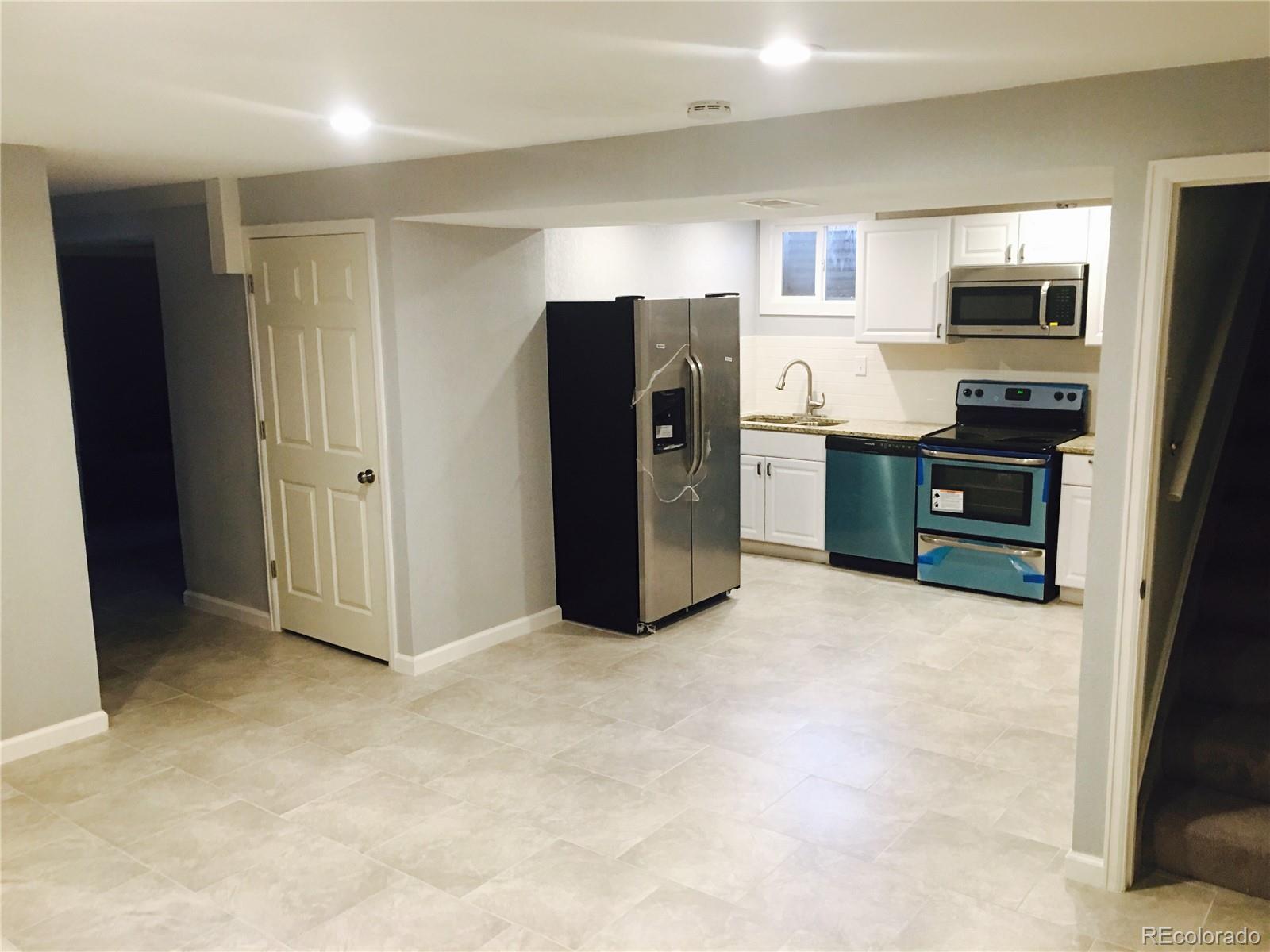 5542 Scranton Street Denver, CO 80239 - Photo 13 of 16 a kitchen with stainless steel appliances granite countertop a refrigerator and a stove top oven