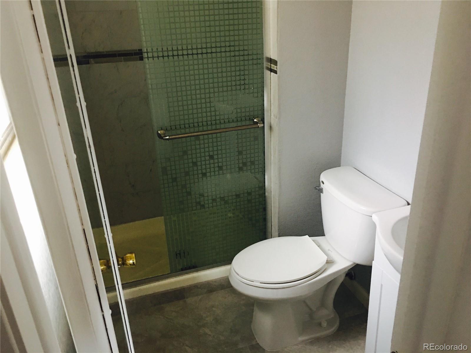 5542 Scranton Street Denver, CO 80239 - Photo 16 of 16 a white toilet sitting next to a shower