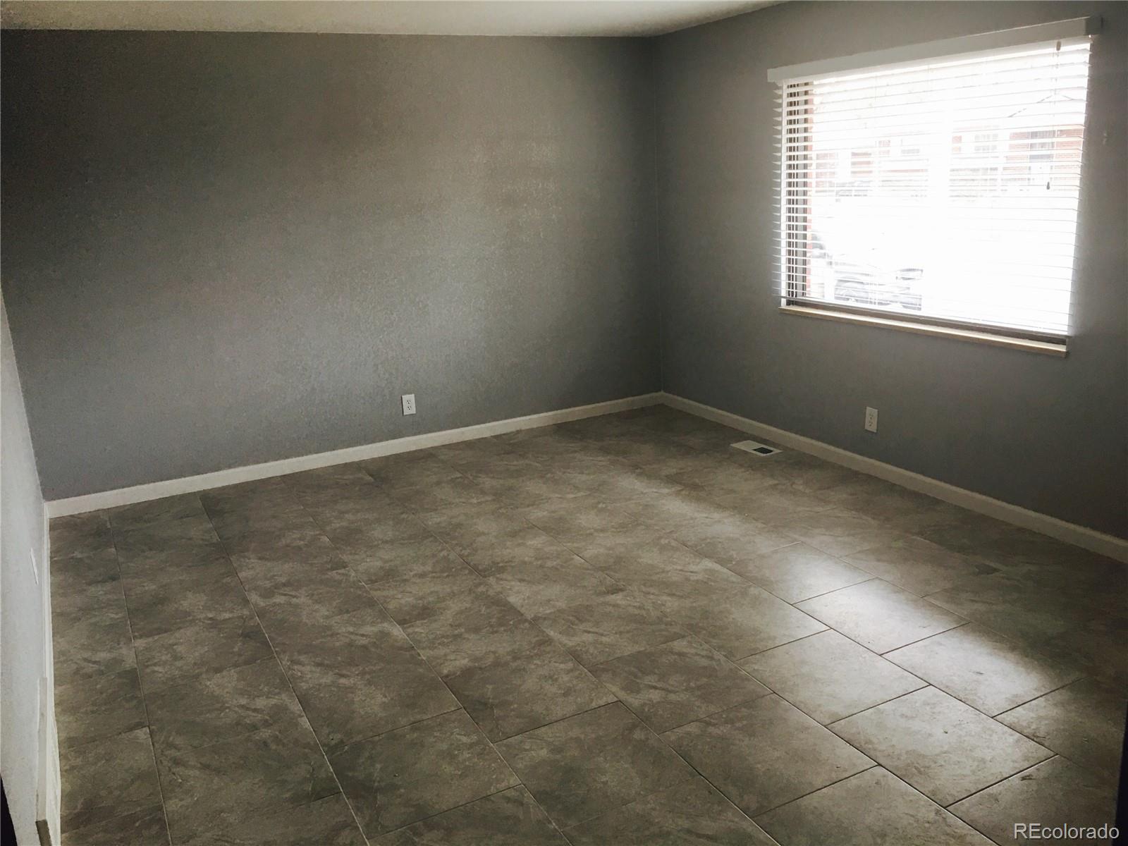 5542 Scranton Street Denver, CO 80239 - Photo 2 of 16 an empty room with a window