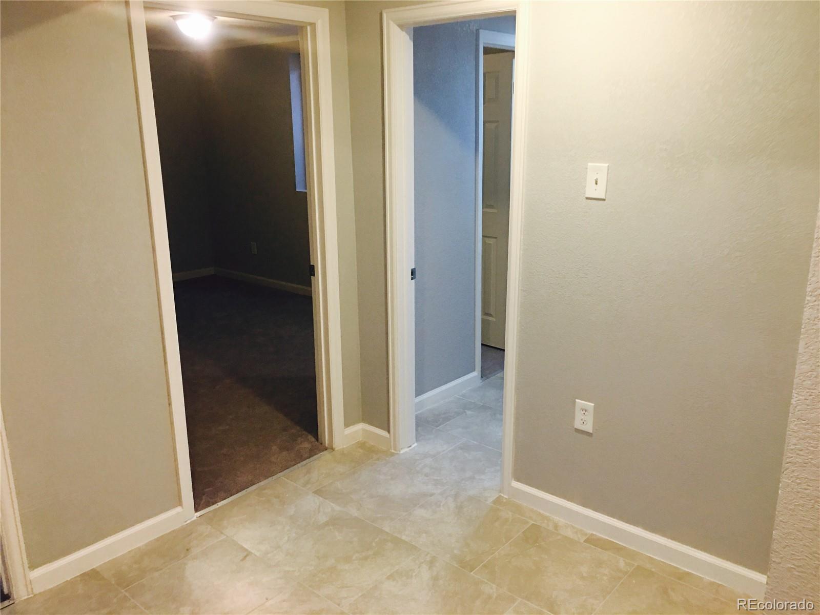 5542 Scranton Street Denver, CO 80239 - Photo 6 of 16 an empty room with mirror