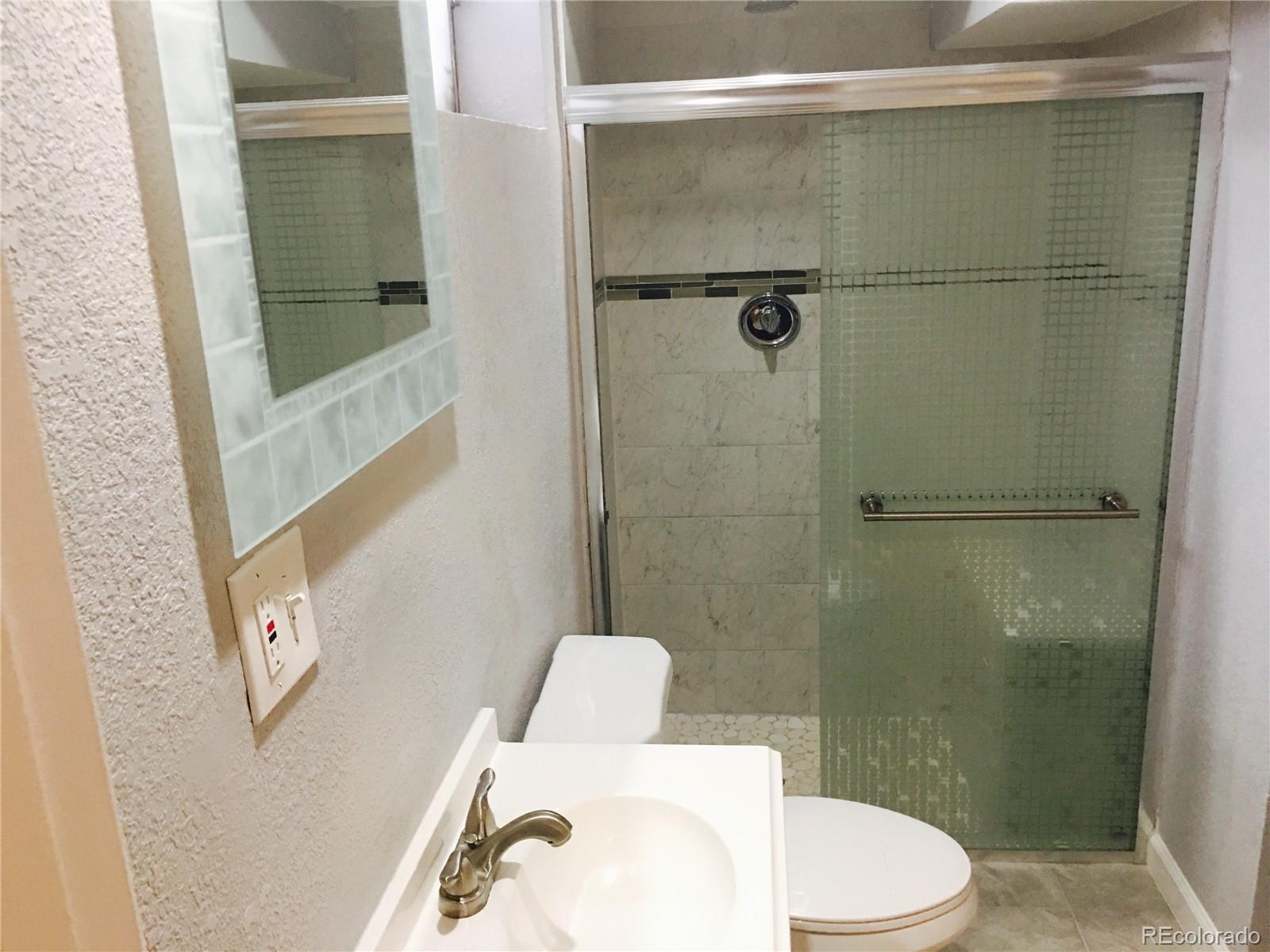 5542 Scranton Street Denver, CO 80239 - Photo 8 of 16 a bathroom with a toilet and a shower