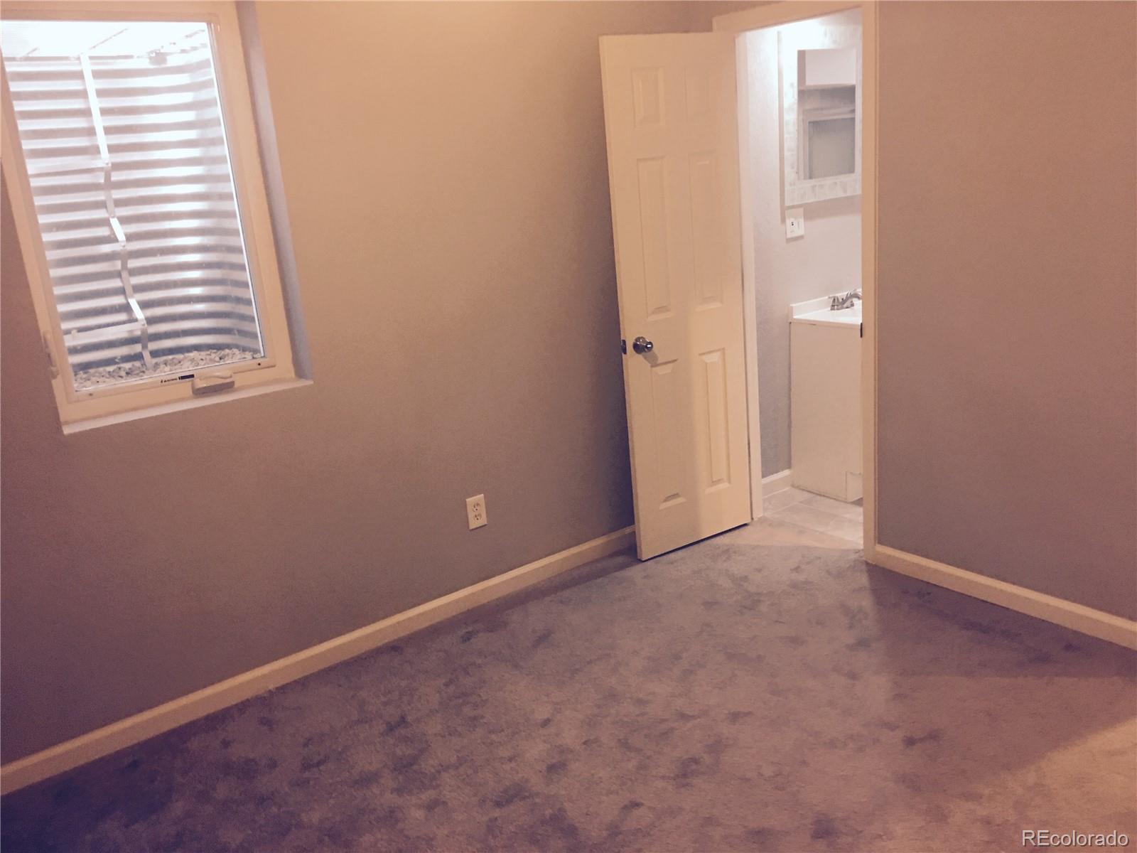 5542 Scranton Street Denver, CO 80239 - Photo 9 of 16 an empty room with windows