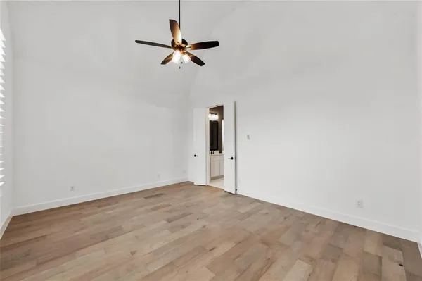 a view of room with a ceiling fan and wooden floor
