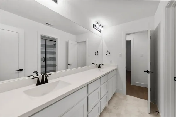 a spacious bathroom with a double vanity sink and a mirror