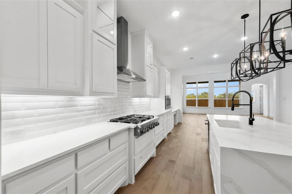 15577 Desert Broom Road Frisco, TX 75035 - Photo 6 of 37 a kitchen with stainless steel appliances a sink stove and cabinets