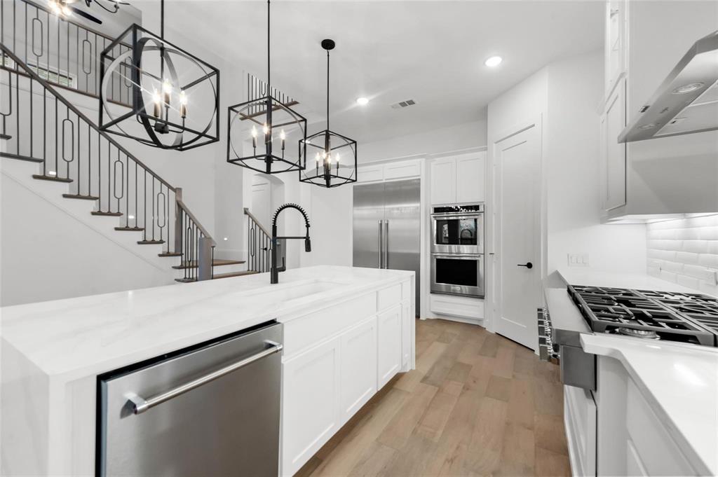 15577 Desert Broom Road Frisco, TX 75035 - Photo 7 of 37 a kitchen with kitchen island stainless steel appliances a stove a sink and a refrigerator