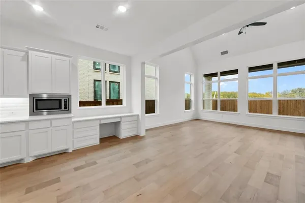 a large white kitchen with granite countertop a large window and a sink