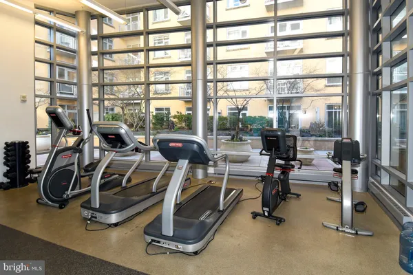 a living room with stainless steel appliances furniture and a flat screen tv