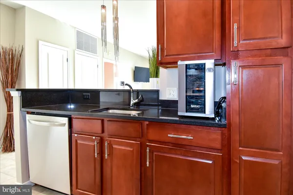 a kitchen with stainless steel appliances kitchen island granite countertop a refrigerator and a stove top oven