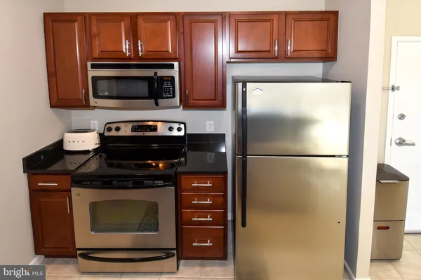 a kitchen with stainless steel appliances granite countertop a sink and a refrigerator