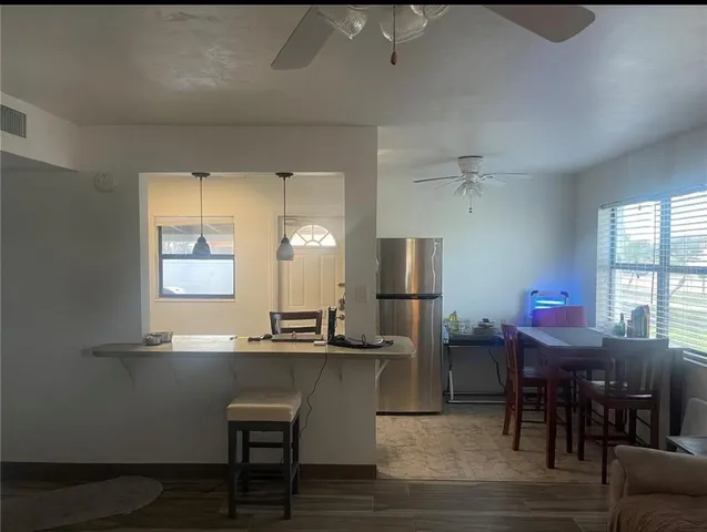 a kitchen with stainless steel appliances a dining table and chairs