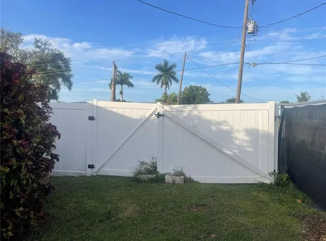 a white house with a big yard and large trees